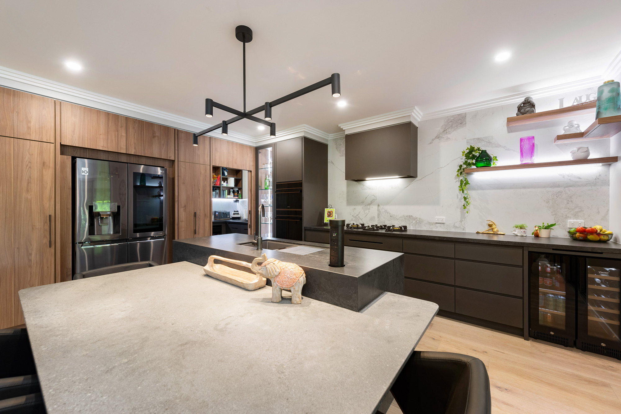 Modern industrial kitchen, concrete look benchtops, marble tile splashback, feature timber cabinetry, black pendant light