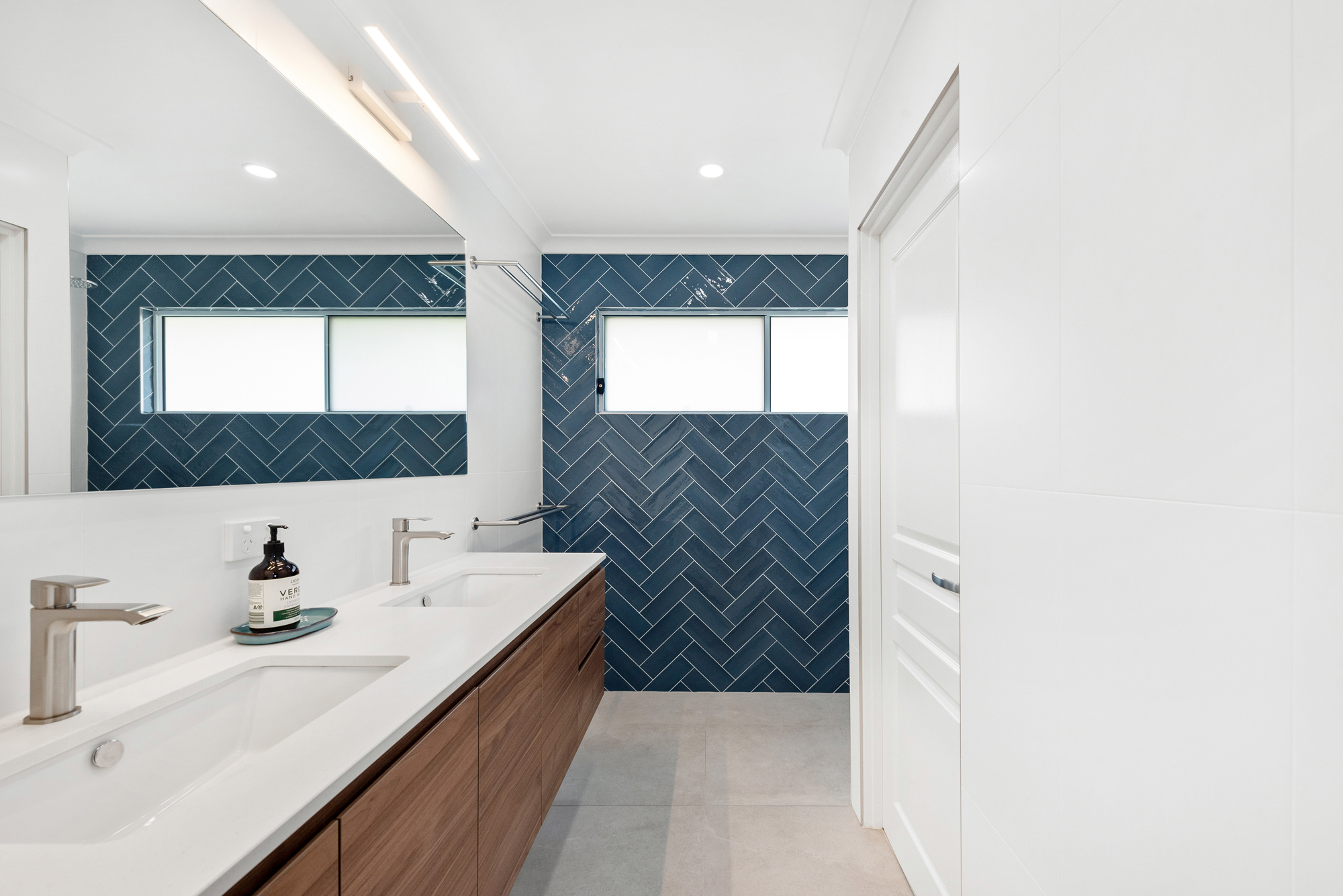 Second storey ensuite navy herringbone tiles separate toilet double basin vanity with mirror lights
